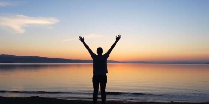 Person celebrating recovery at sunrise by tranquil lake.